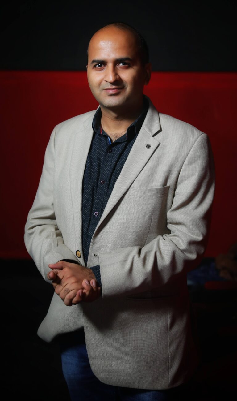 Portrait of Hitesh Motwani, forward deployed engineer and corporate AI trainer, in a light blazer